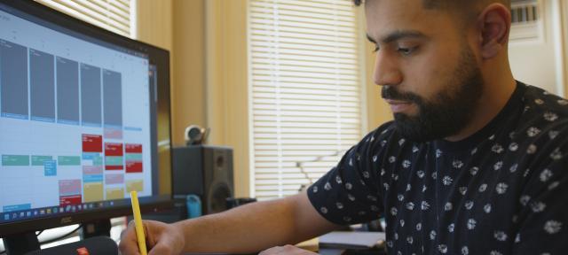 Marlon Becerra working at a computer in his dorm room.