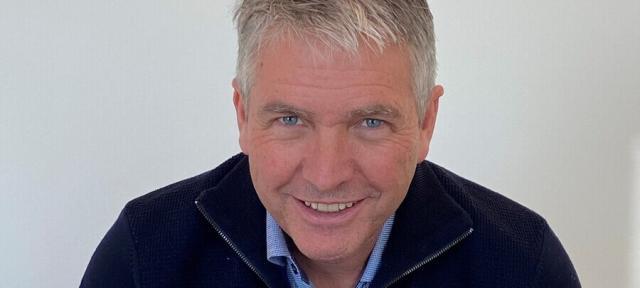 A person in a blue top smiling.
