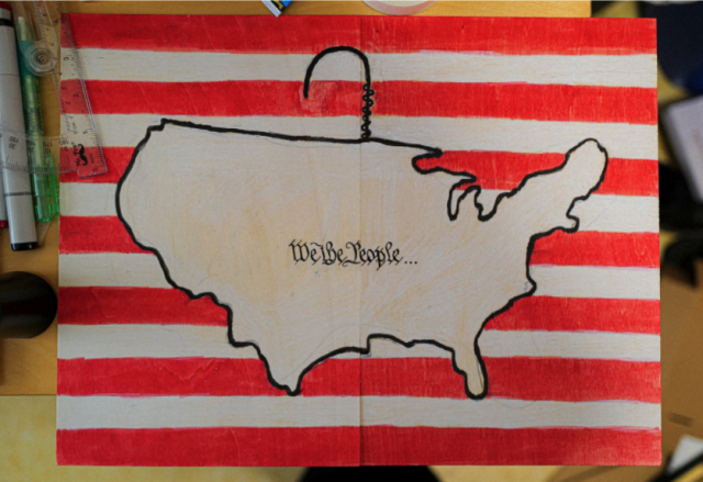 Phoebe Chen's Div II project. A map of the US surrounded by a coat hanger on a background of red and white stripes.