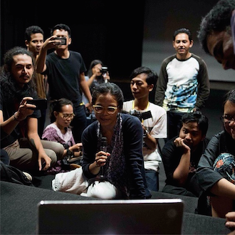 Participants at Festival Film Dokumenter in Yogyakarta discuss Ravett&#039;s work with the filmmaker via Skype