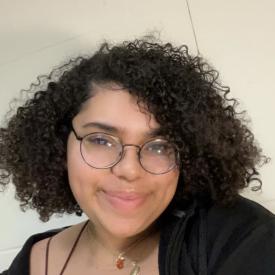 A person in glasses and a black top smiling.