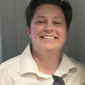 A person in a white shirt smiling.