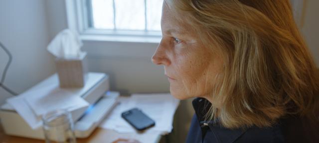 Author Elizabeth Brundage writing at her desk.