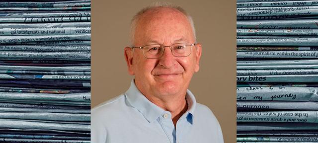 Ken Garfield and stacked newspapers
