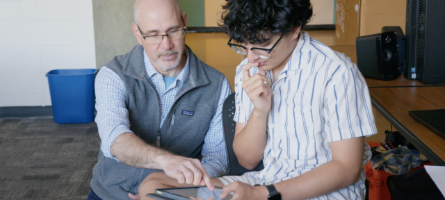 Jeff Barton helps a student using an tablet.