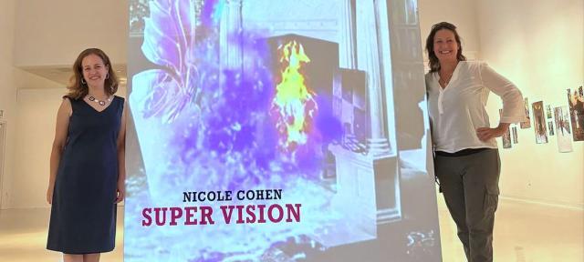 Nicole Cohen and Karen Levitov with Super Vision banner