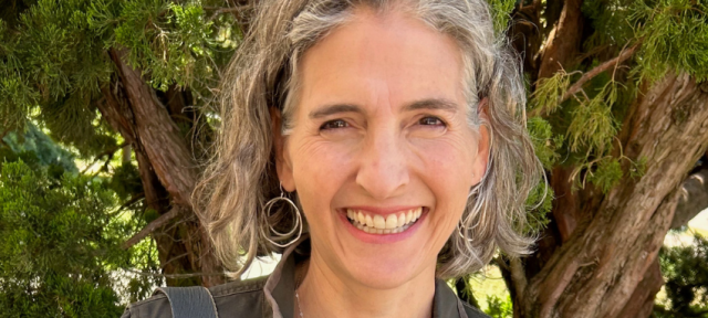 Lise Sanders smiling at the camera. She is standing outdoors.