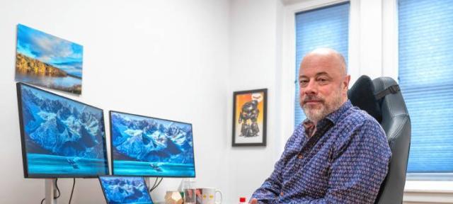 Joe Minton sitting at a desk with multiple screens