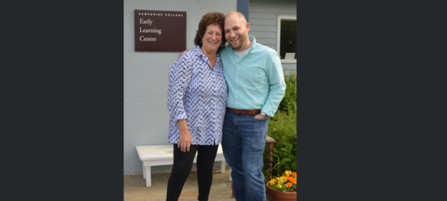 Two people standing in front of the Early Learning Center smiling.