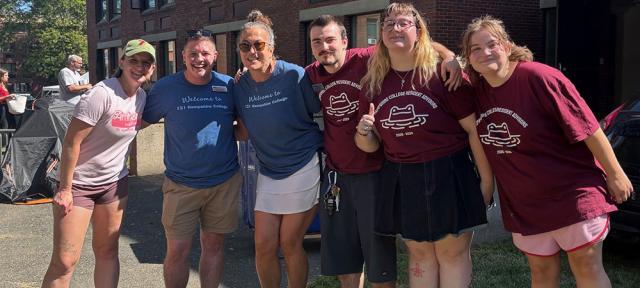 Students and staff with arms around each other smiling