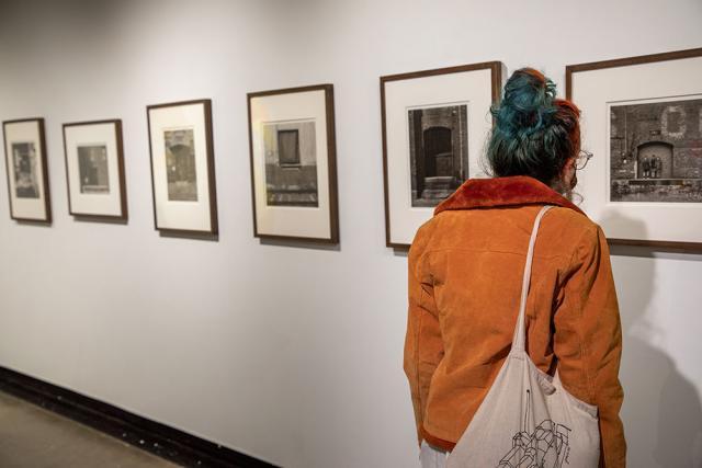 Viewer looks at photographs on the gallery wall