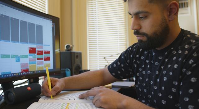 Marlon Becerra working at a computer in his dorm room.