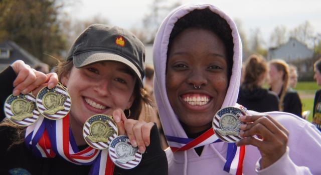 Womens Track and Field winners hold up awards