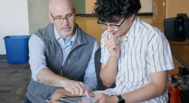 Jeff Barton helps a student using an tablet.