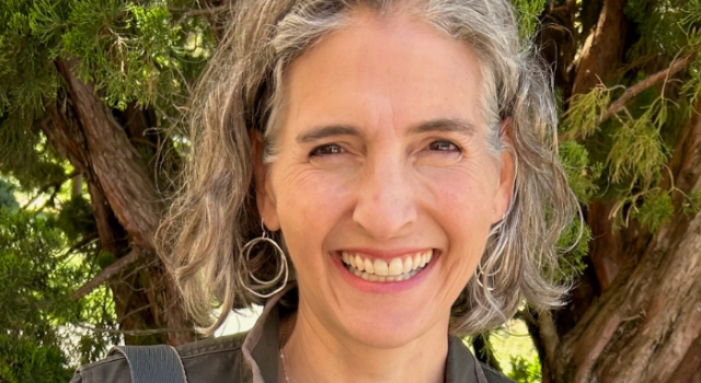 Lise Sanders smiling at the camera. She is standing outdoors.