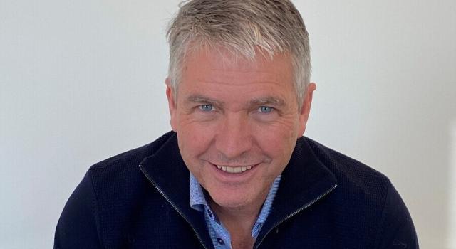 A person in a blue top smiling.