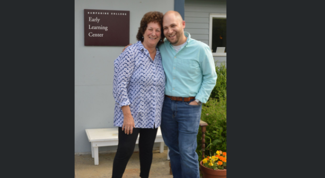 Two people standing in front of the Early Learning Center smiling.