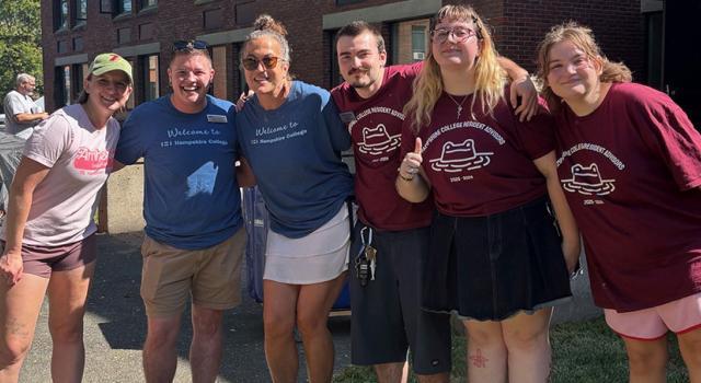 Students and staff with arms around each other smiling