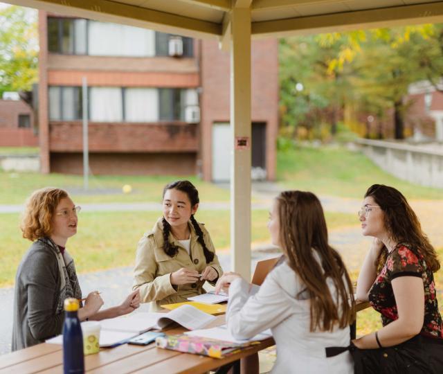 Students sitting at a picnic table working together.