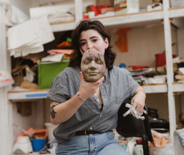 Student in Art Barn holding ceramic face