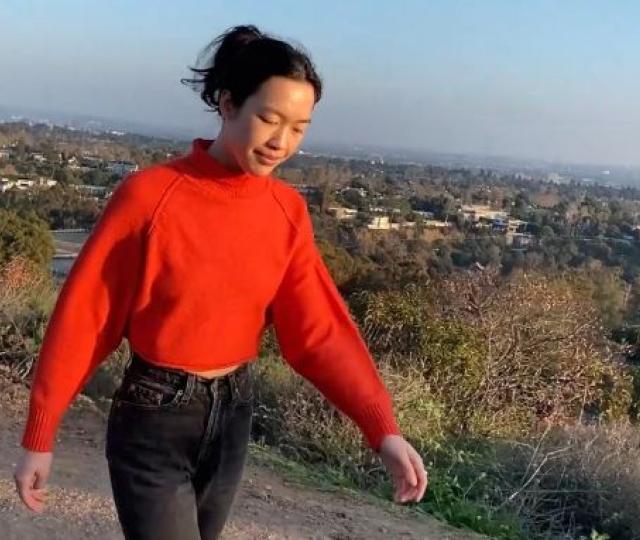 Student Daily walking on a hill in a red sweater.