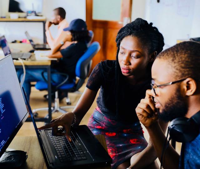 Two people working at a computer.