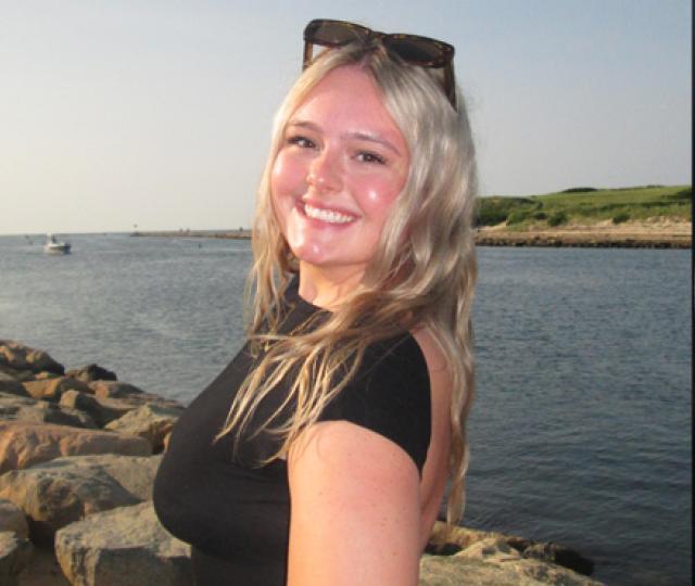 Anneka Johnson smiling next to the water and a microplastics sample under a microscope