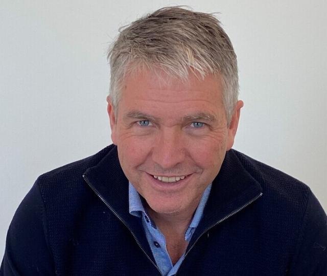 A person in a blue top smiling.