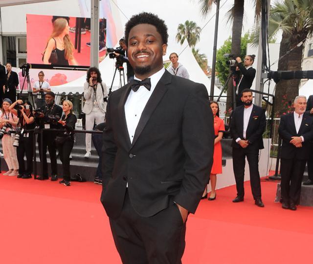 Jacory Martin, in a tux, smiling from the red carpet at Cannes Film Festival