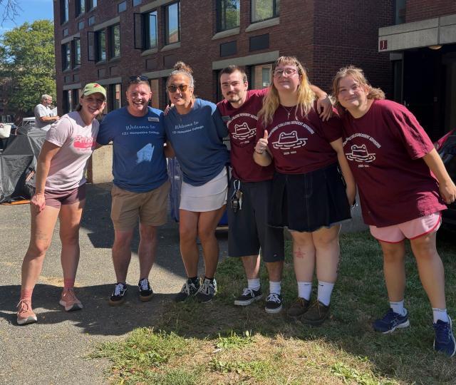 Students and staff with arms around each other, smiling