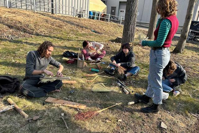 Students making brooms outside