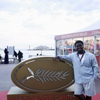 A person standing by a Cannes sign.
