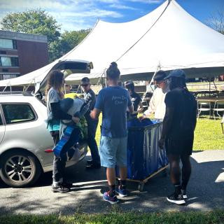 Students moving in with tent in background