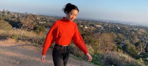 Student Daily walking on a hill in a red sweater.