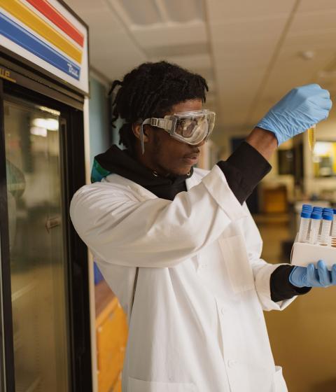 Student in science lab holds up test tube.