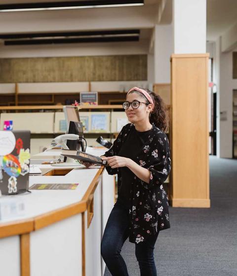Students chatting at the library desk.