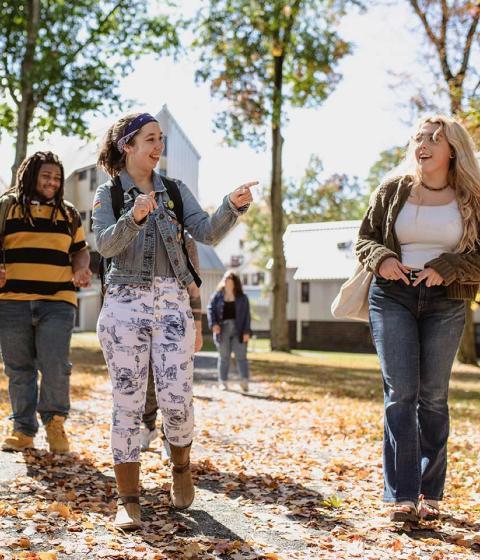 Students chat and walk together outside on campus.