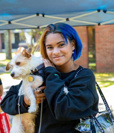 Student on moving into Hampshire College holding a dog.