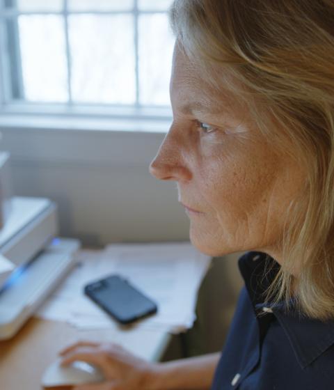 Author Elizabeth Brundage writing at her desk.