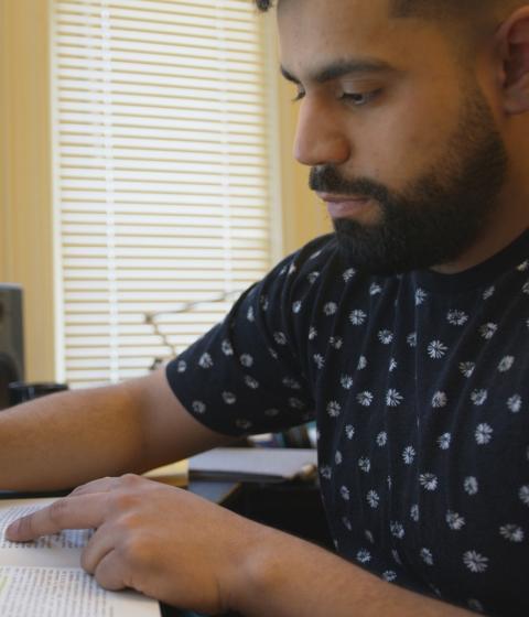 Marlon Becerra working at a computer in his dorm room.