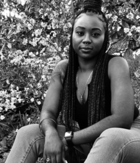 Author Shaina Jones sits in a black and white photo, beside it is the cover of her book "To Be Named Something Else." 