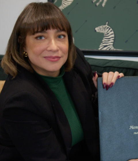 Daliza Dova looks at the camera holding up her Hampshire College diploma. 