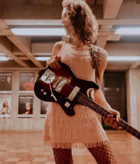 On the left: A photo of Olivia holding a guitar. On the right: The cover of Olivia's album "Just Enough."