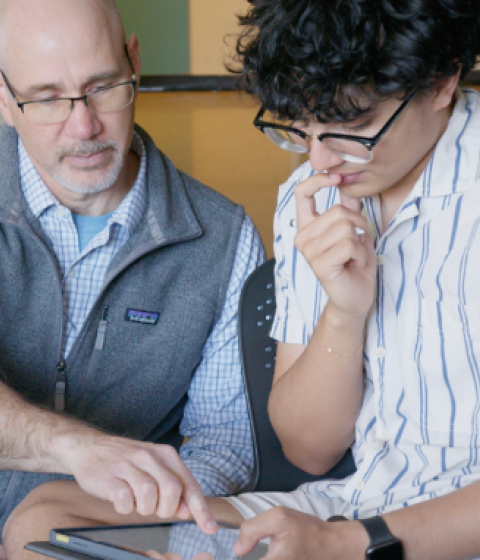 Jeff Barton helps a student using an tablet.