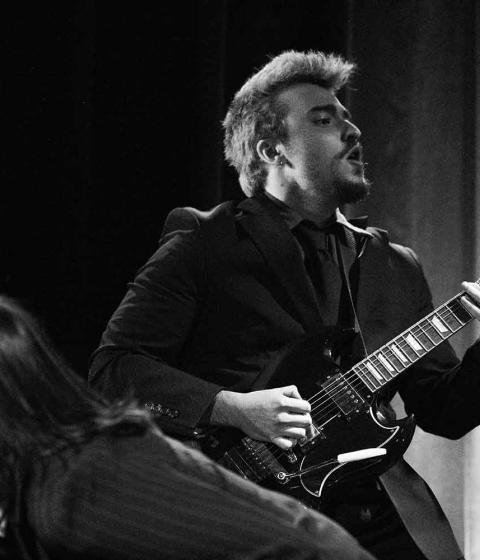 Levi Ebnit playing guitar in his band, 