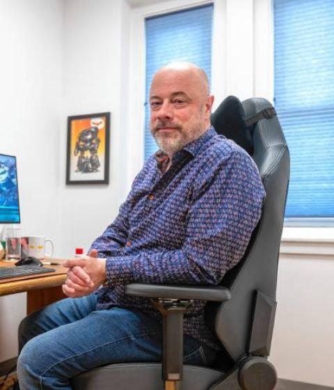 Joe Minton sitting at a desk with multiple screens