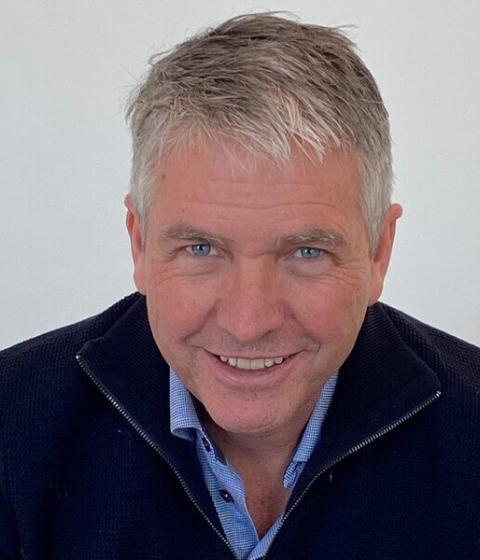 A person in a blue top smiling.