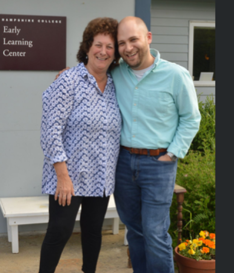Two people standing in front of the Early Learning Center smiling.
