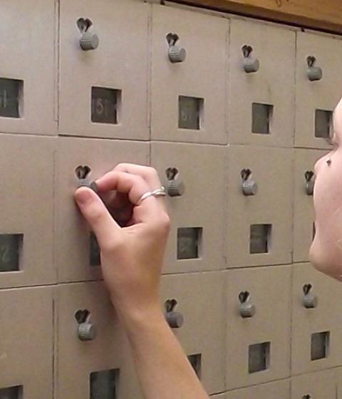 Student opening mailbox at Hampshire College Mail Room
