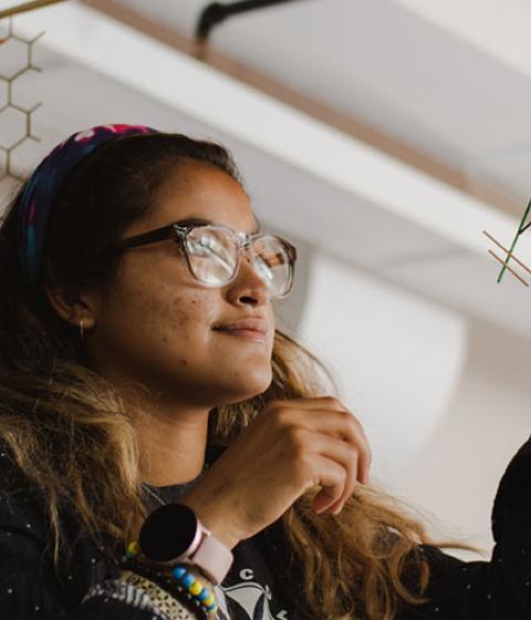 student working on a model in class